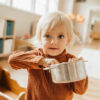 child playing with metal pot